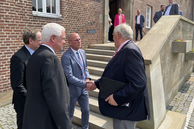 Peter Hinze begrüßt NRW-Minister Laumann vor dem Emmericher Rathaus.