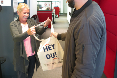 Simone Peters, Mitarbeiterin im Emmericher Bürgerbüro, überreicht eine Neubürgertasche.