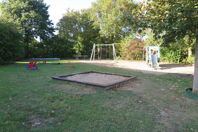 Gesatmübersicht des Spielplatz mit Sandkasten, Wippe und Minibagger